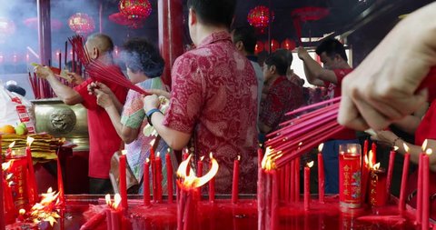 JAKARTA - Indonesia. March 26, 2018: Buddhist people praying with burning incense sticks on Chinese New Year celebration at Jin De Yuan temple, Glodok, Jakarta. Shot in 4k resolution