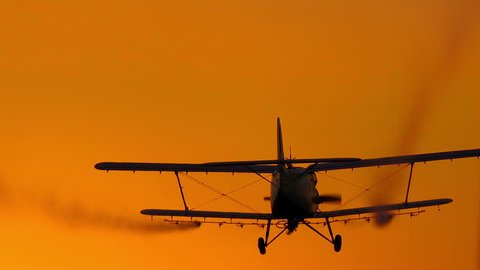 spray plane crop duster silhouette at sunset