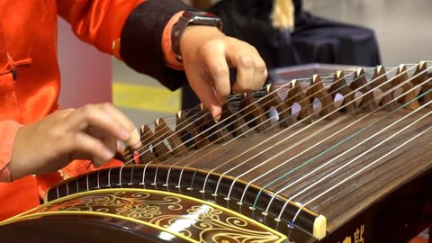 Chinese traditional musician playing chinese guzheng, 