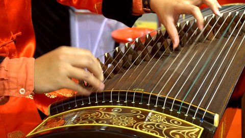 Chinese traditional musician playing chinese guzheng, 
