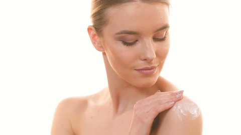 The cute woman applying a cream on the skin on the white background