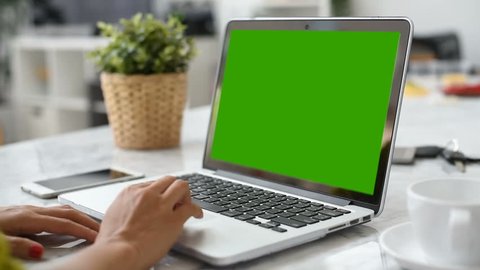 Woman hand using laptop with key green screen. Lady hand typing on a laptop computer.
