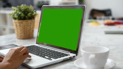 Woman hand using laptop with key green screen. Lady hand typing on a laptop computer.