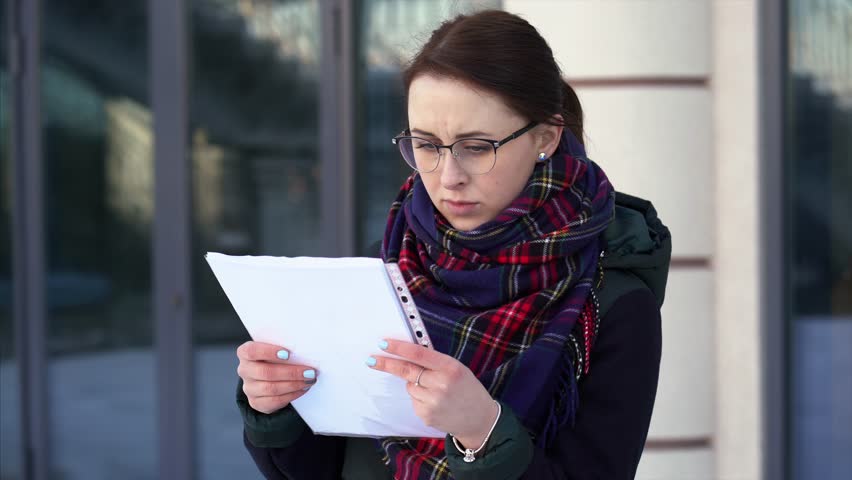 girl woman near business center reading and looking at documents. 