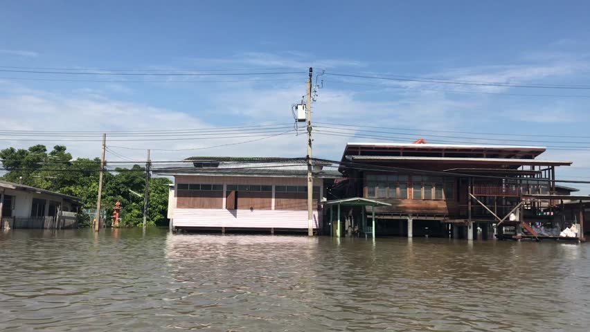 Bangkok from the Chao Phraya river. Traffic on the river. Houses on the water. The boat trip.
