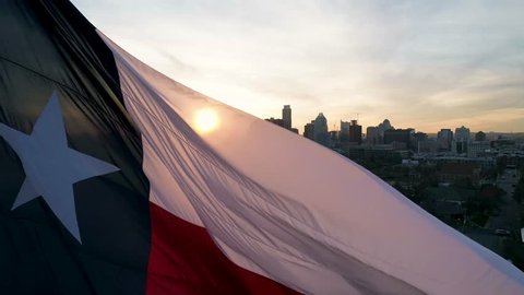 This is an orbiting aerial of a blowing Texas flag in Austin.