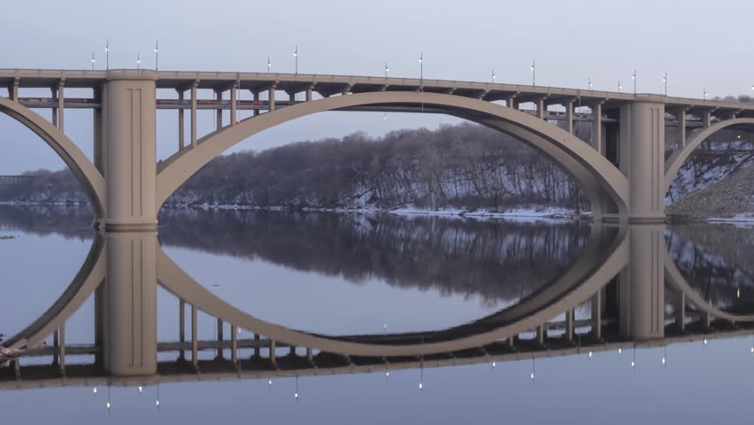 A Wide Angle Shot of the New Franklin Bridge Spanning and Reflecting in a Calm Mississippi River during a Late Winter Dusk