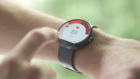  MONTREAL, CANADA - May 2015 :  Smartwatch (wearable computer) used as a heart rate pulse health device. Global wearables market will hit 148 million units shipped in 2019.