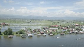 Drone point of view, aerial view over Inle lake, Myanmar at daytime, reflection on water surface, floating garden view and rowboat navigating through the canals. Travel nature beautiful Asia concept