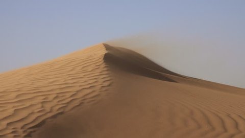 Sand blowing over sand dunes in wind, Sahara desert, 4k