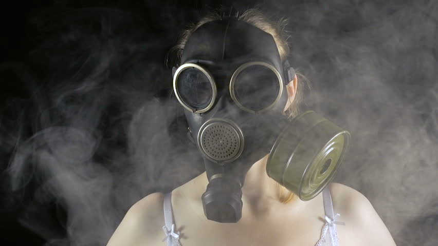 Young girl in gas mask and smoke