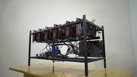 Future with a lot of money without doing anything. All happy young smiling man hugging his gpu mining btc rig machine with powerful graphics cards, concept cryptocurrency computer, symbolic shot.