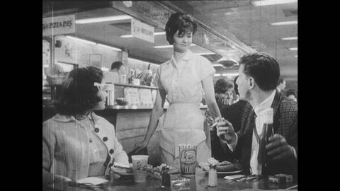 1960s: Diner. Couple talks to waitress. Woman walks away.