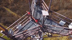 Close up video of Base transceiver station tower (BTS) on green meadow and forest from above (with drone). Bts tower on spring.