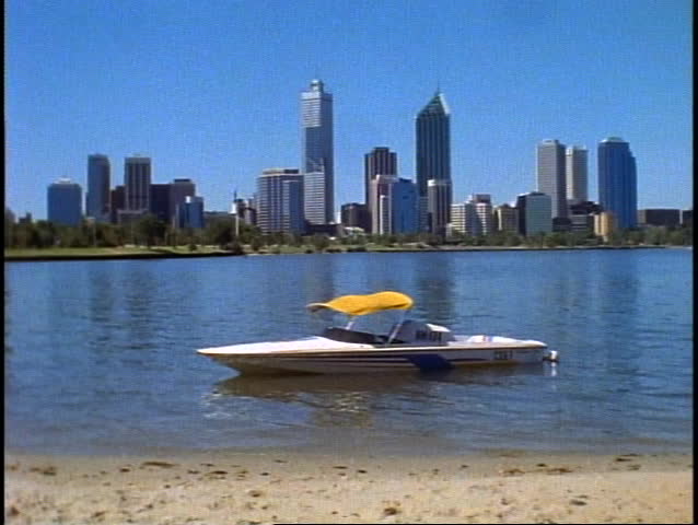 AUSTRALIA, 1999, Perth, wide establishing skyline shot with lake, boat, and beach in foreground