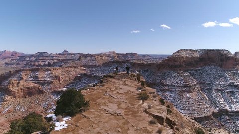 Aerial view flying over 3 people at a view point in the desert overlooking the Little Grand Canyon at the Wedge in the San Rafael Swell. Stockvideó