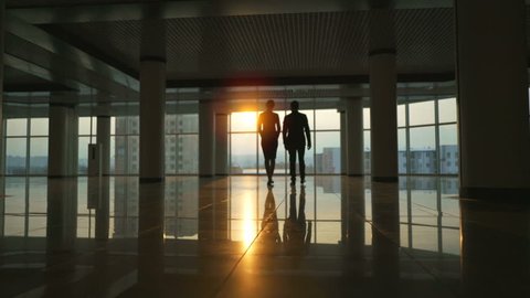 The business man and a woman walking in the modern office. slow motion