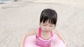 cute girl wear lifebuoy and playing happily on the beach