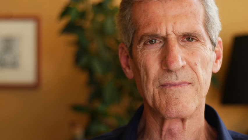 Realxed pensive old man looking at camera- close up