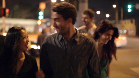 Group of friends on night out walk along street towards camera.Shot on Sony FS700 in PAL format at a frame rate of 25fps
