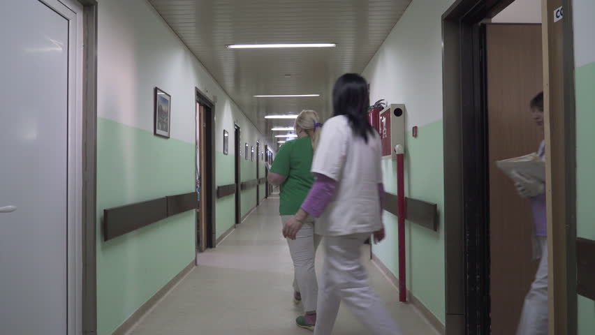 Nurses team holding in hands medical documentation and walking through the hall of hospital department and coming in room, concept medicine, steady cam, tracking, gimbal, overhead shot, interior scene | Shutterstock HD Video #1009536605