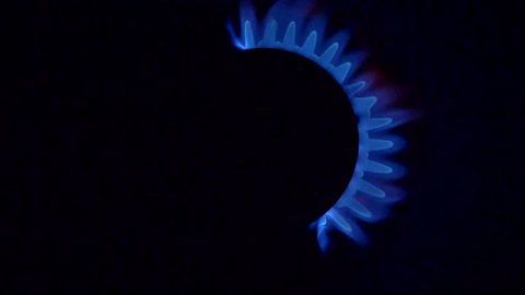 Gas stove is switching on. Black background. 