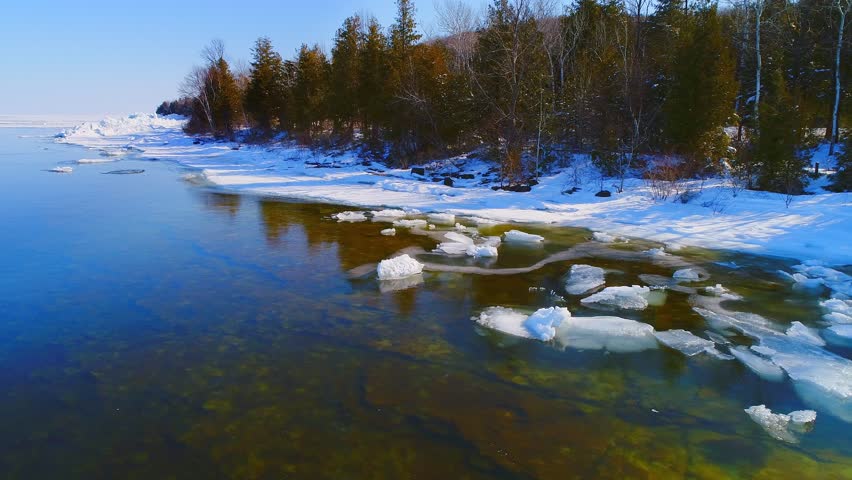 Tranquil scenic shoreline of Door County Wisconsin in icy Spring, aerial view.
