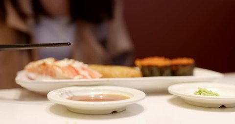 Woman eating sushi in Japanese restaurant