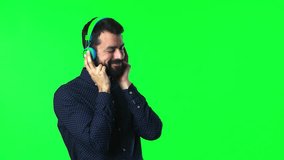 Handsome man listening music with beard  on green screen chroma key