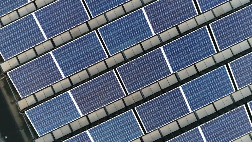 Aerial top down view moving up above solar panels PV modules mounted on flat roof photovoltaic solar panels absorb sunlight as a source of energy to generate electricity creating sustainable energy 4k Royalty-Free Stock Footage #1009576289
