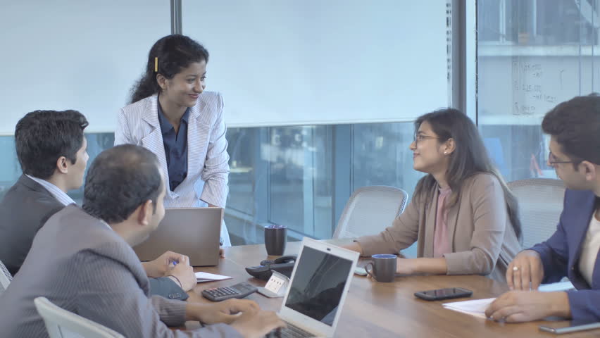 A group of mixed gender office colleagues discussing in a meeting on business development in a conference room of a modern office. A young female leader conducting a board meeting in a boardroom Royalty-Free Stock Footage #1009576721