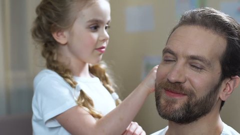 Caring daughter combing father hair and kissing cheek, family love, parenthood