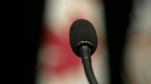 Close up of microphone in front of canadian flag