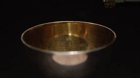 Filling golden cup with wine slow motion