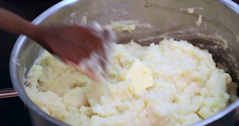 Woman add butter to mashed potatoes