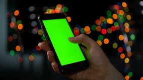 Close-up of a smartphone with a green screen. Scrolling the screen.