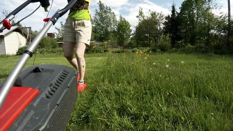 The girl mowing the lawns. Shot in 4K (ultra-high definition (UHD)), so you can easily crop, rotate and zoom, without losing quality! Real time.