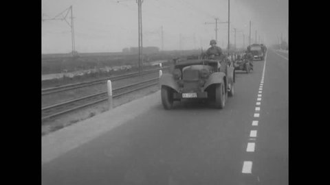 CIRCA 1940 - German motorized troops drive through the countryside and village of Haarlem, the Netherlands.