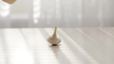 Two wooden spinning tops on a table. Closeup