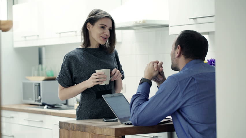 Businesspeople talking and drinking in the kitchen at home
