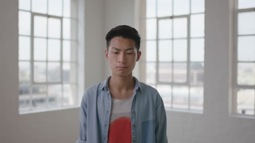 close up portrait of young asian man student texting browsing messages using smart watch mobile technology in apartment windows background real people online communication