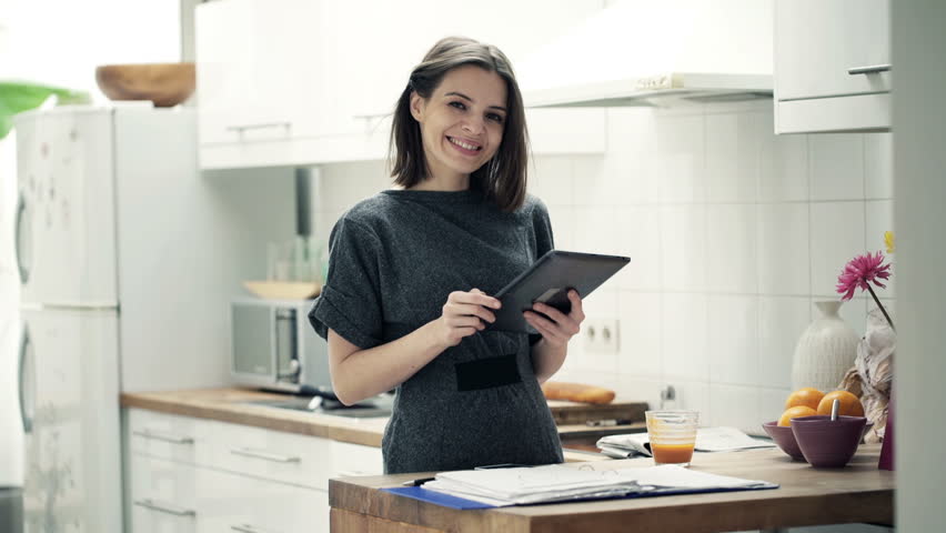 Portrait of happy, successful businesswoman with tablet computer at  sitting kitchen
 | Shutterstock HD Video #10096139