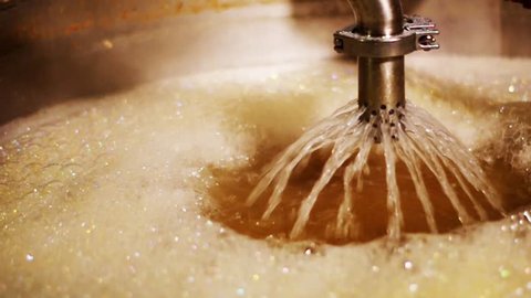Closeup boiling hot liquid filtering during beer brewing process
