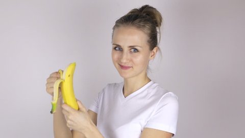 Cute girl eats banana. Young woman with banana