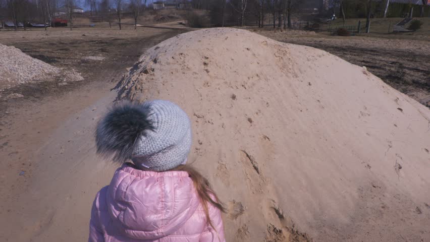 Little girl on sand pile