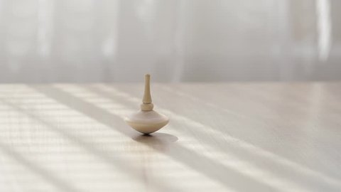 Wooden spinning top on a table. Closeup