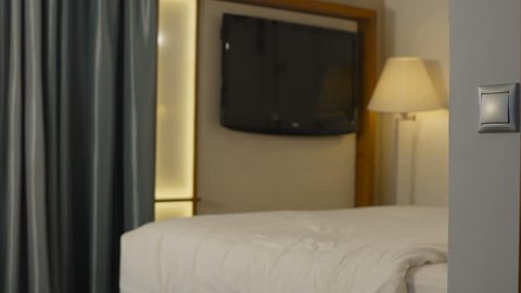 Adult man in suit entering hotel room and taking sit on comfortable bed having business trip.