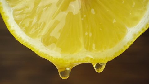 Honey dripping from slice lemon - close-up