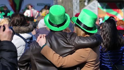Celebration of St. Patrick day in Moscow. Unrecognizable loving couple in green hats on concert