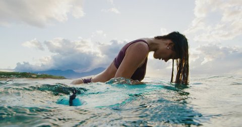 Beautiful surfer girl flipping her hair back at sunset in slow motion, summer lifestyle